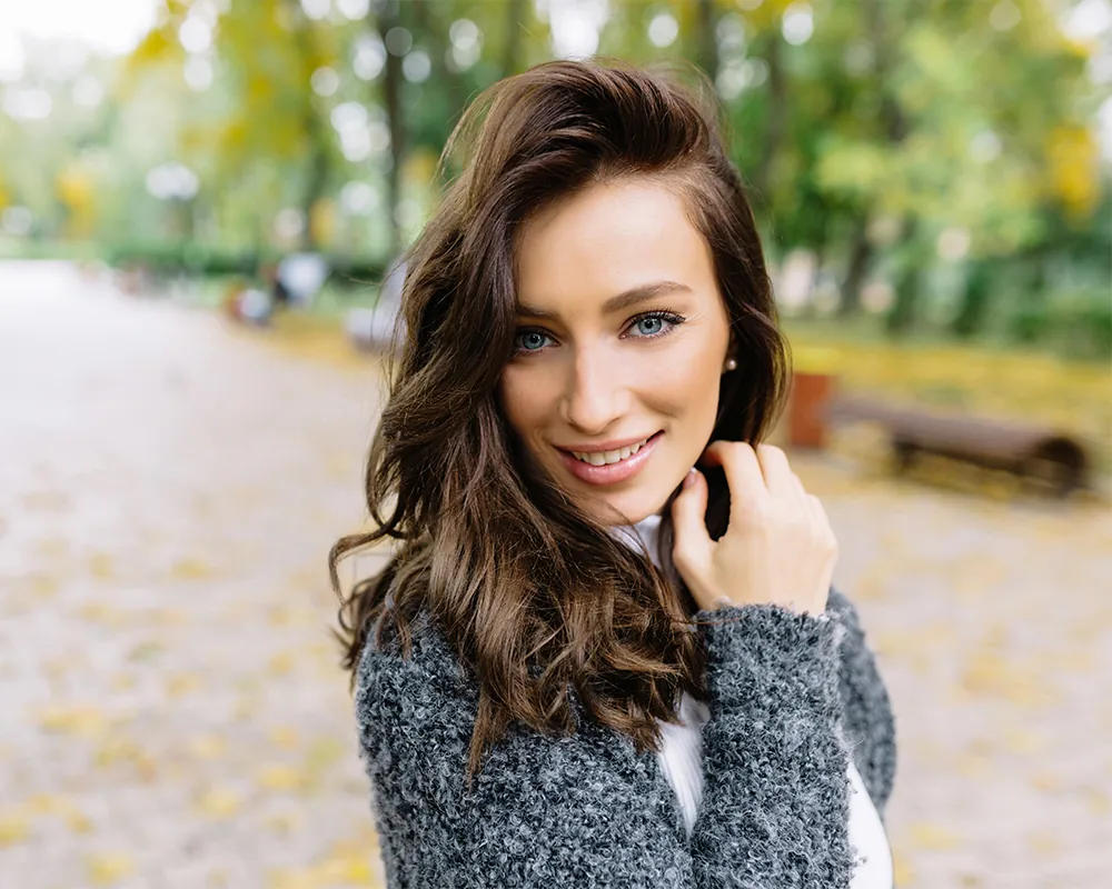 Beautiful woman in park looking at camera