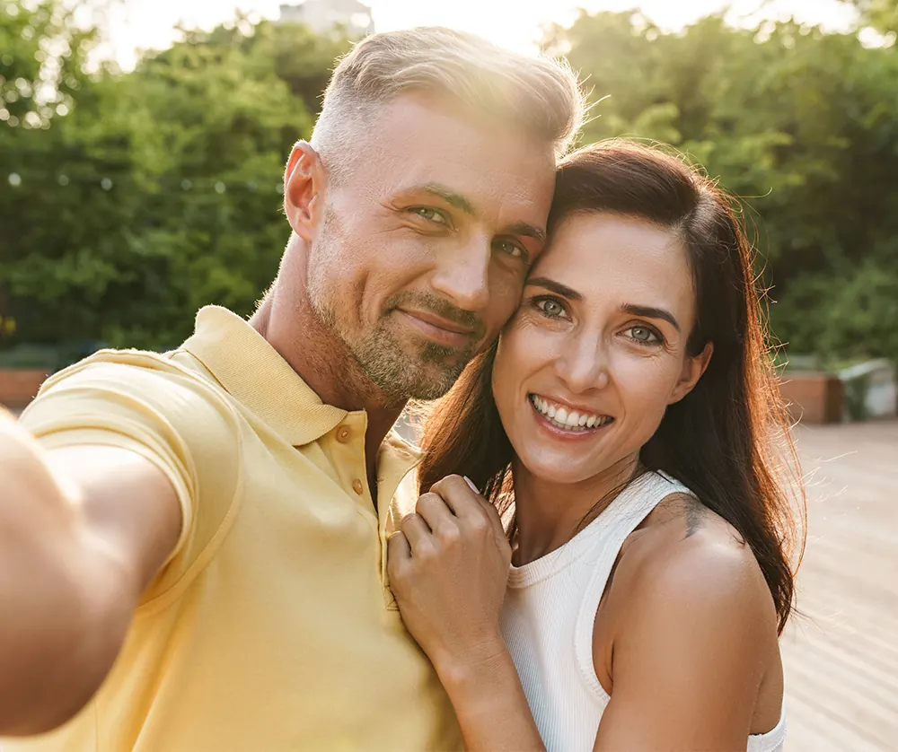 beautiful happy couple taking picture together in park